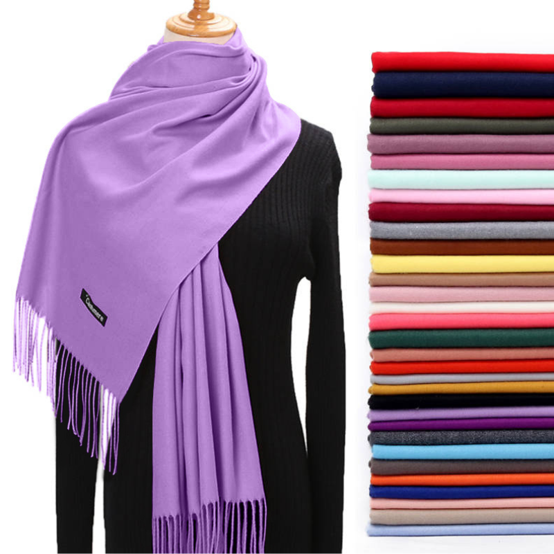 Purple scarf on a mannequin with a stack of folded scarves in various colors.