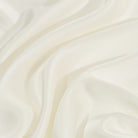 Close-up of smooth, ivory silk pillowcase with soft folds